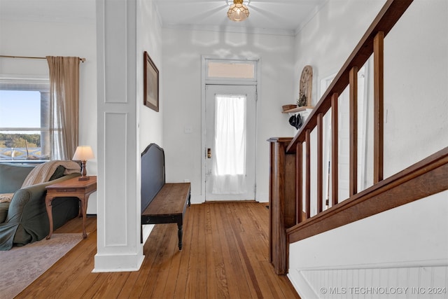 foyer entrance with ornamental molding and light hardwood / wood-style floors