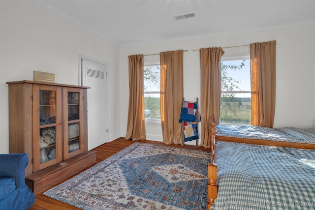 bedroom with ornamental molding and hardwood / wood-style floors