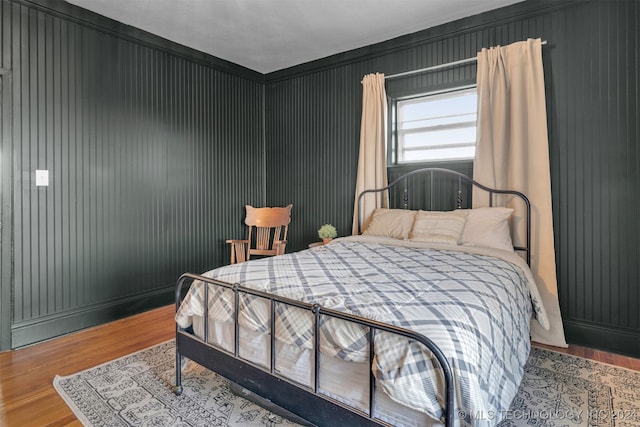 bedroom with crown molding and hardwood / wood-style floors