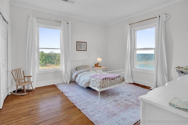 bedroom with crown molding and wood-type flooring