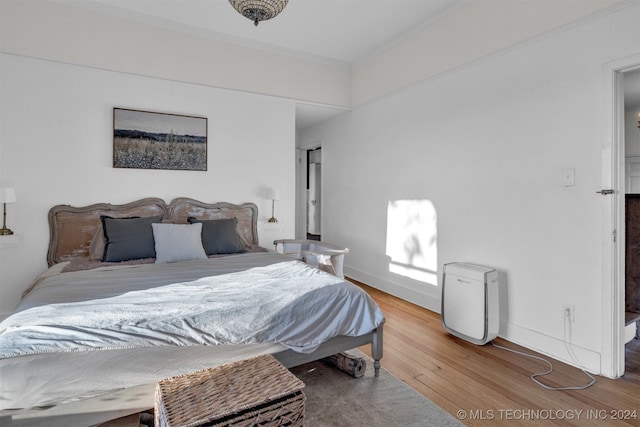 bedroom featuring ornamental molding and hardwood / wood-style floors