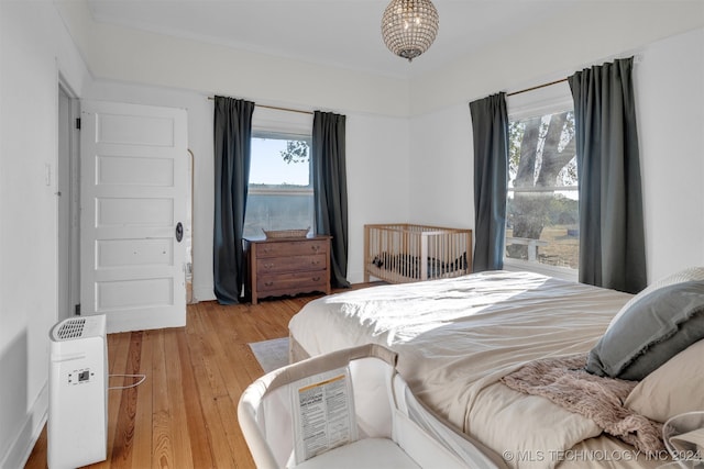 bedroom with light wood-type flooring and multiple windows