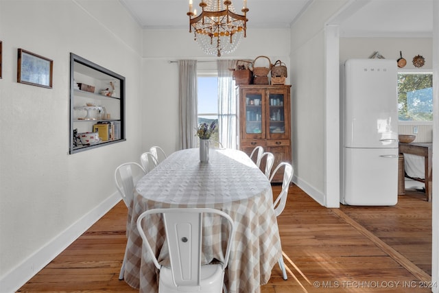 dining room with ornamental molding, a chandelier, and wood-type flooring