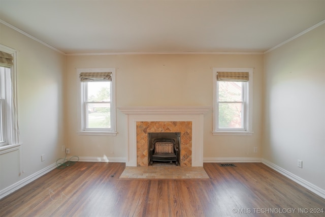 unfurnished living room with plenty of natural light, ornamental molding, dark hardwood / wood-style flooring, and a wood stove