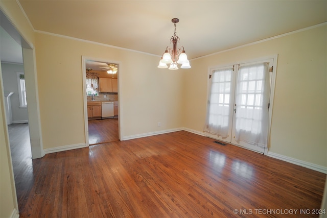 unfurnished dining area with dark wood-type flooring, french doors, ornamental molding, and an inviting chandelier