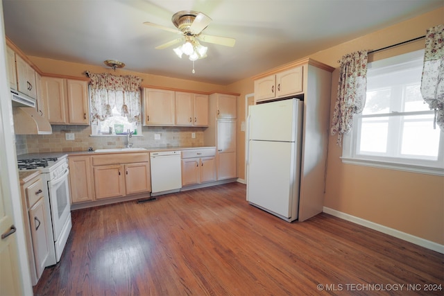 kitchen featuring light brown cabinetry, tasteful backsplash, white appliances, and a wealth of natural light