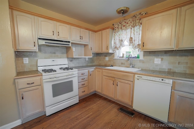 kitchen featuring tasteful backsplash, white appliances, sink, hanging light fixtures, and hardwood / wood-style flooring