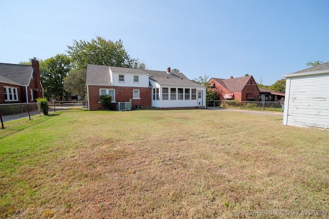 back of house featuring central AC and a lawn