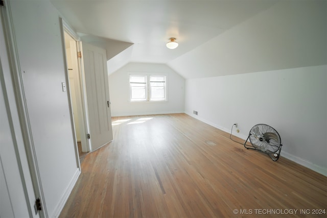 additional living space featuring vaulted ceiling and hardwood / wood-style floors