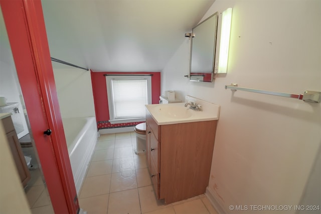 bathroom featuring vanity, toilet, tile patterned flooring, a tub, and vaulted ceiling