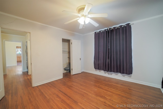 unfurnished bedroom featuring ceiling fan, ornamental molding, a closet, and hardwood / wood-style floors