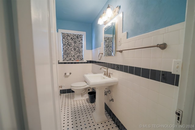 bathroom featuring sink, tile patterned flooring, tile walls, and toilet