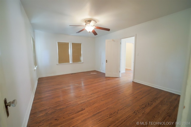 empty room with ceiling fan and dark hardwood / wood-style floors