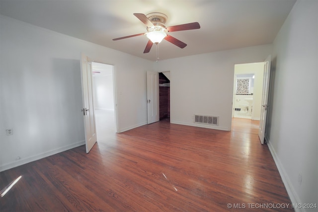 empty room with dark hardwood / wood-style flooring and ceiling fan