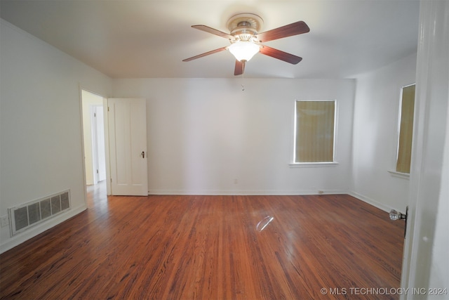 unfurnished room with ceiling fan and dark wood-type flooring