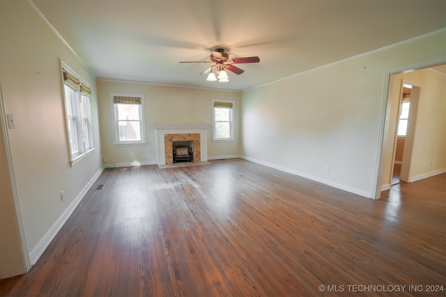 unfurnished living room with ornamental molding, dark hardwood / wood-style flooring, a wealth of natural light, and ceiling fan