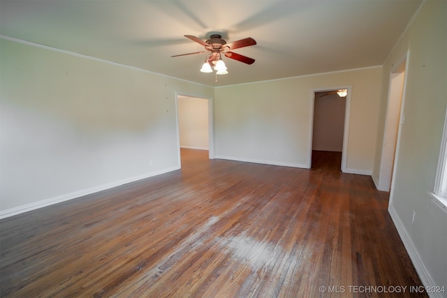 empty room featuring ceiling fan, ornamental molding, and dark wood-type flooring