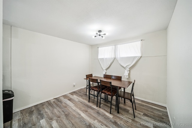 dining area with wood-type flooring and a chandelier