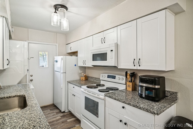 kitchen featuring white appliances, white cabinets, and stone countertops