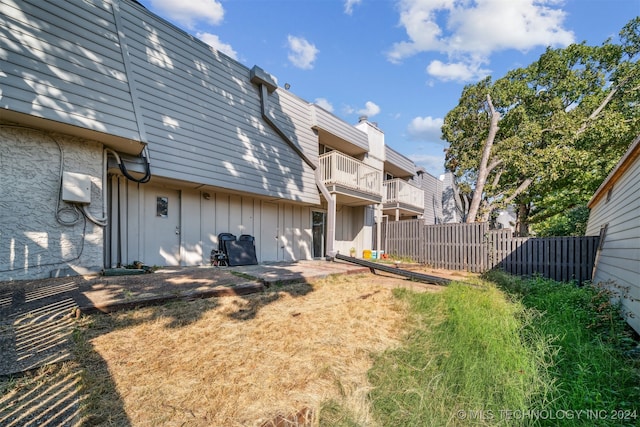 back of property with a balcony and a patio area