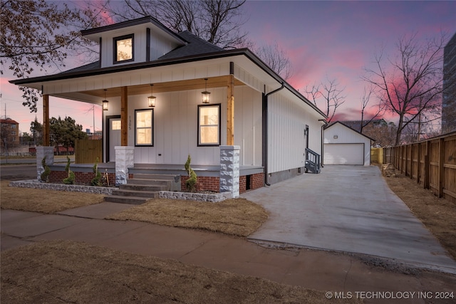 view of front facade with an outdoor structure, a porch, and a garage