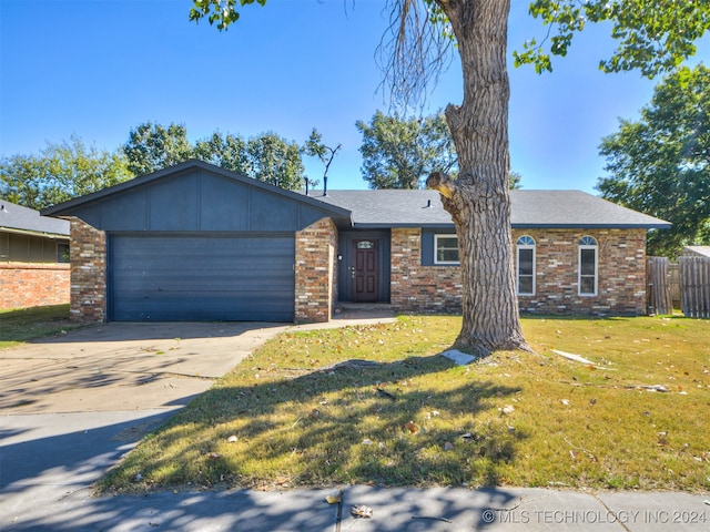 ranch-style home featuring a garage and a front lawn