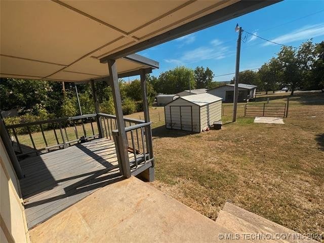 view of yard featuring a wooden deck and a storage unit