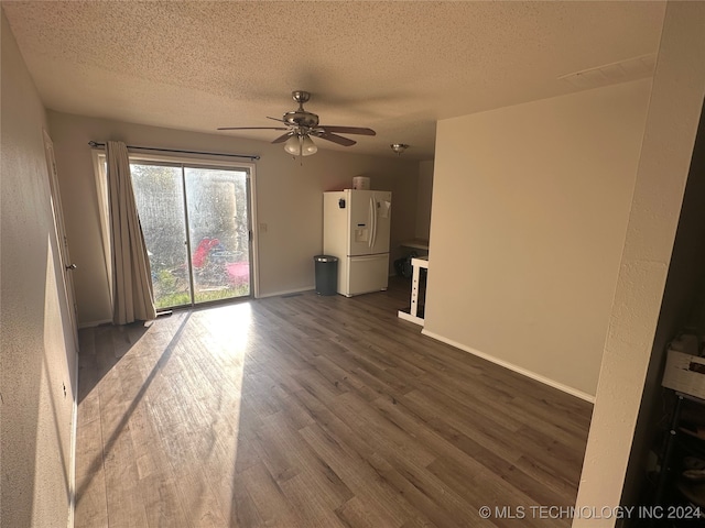 unfurnished living room with dark wood-type flooring, a textured ceiling, and ceiling fan