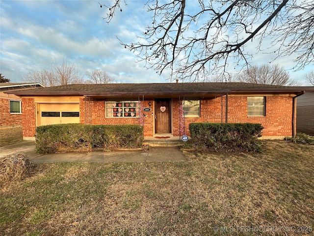 ranch-style house featuring an attached garage, a front lawn, and brick siding