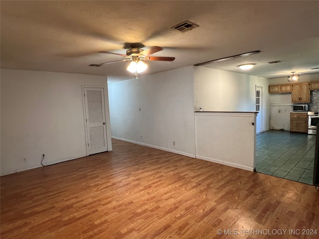 empty room featuring wood-type flooring, a textured ceiling, and ceiling fan