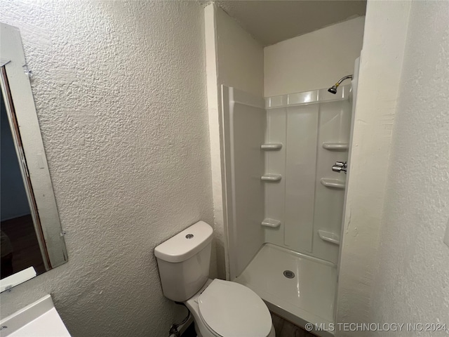 bathroom featuring toilet and a shower