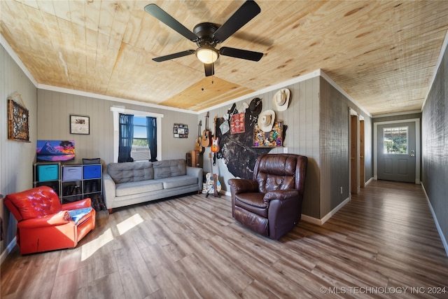 living room featuring ceiling fan, ornamental molding, wooden walls, hardwood / wood-style flooring, and wooden ceiling