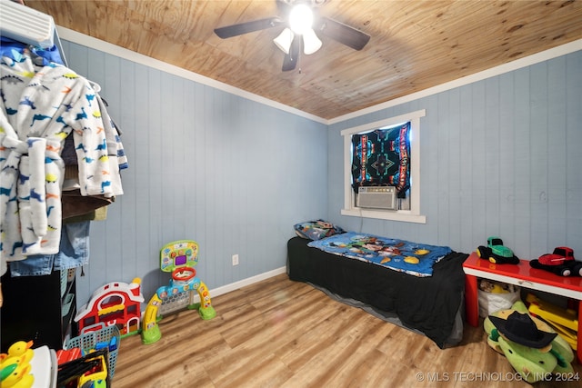 bedroom featuring ceiling fan, wood walls, hardwood / wood-style flooring, wooden ceiling, and crown molding