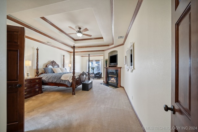 bedroom with light colored carpet, ceiling fan, crown molding, and a raised ceiling