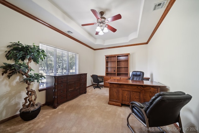 office area with ceiling fan, a tray ceiling, ornamental molding, and light colored carpet