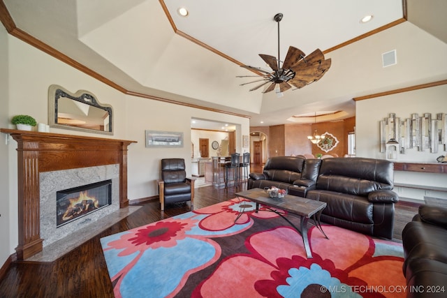 living room featuring a raised ceiling, a high end fireplace, a notable chandelier, dark hardwood / wood-style floors, and ornamental molding