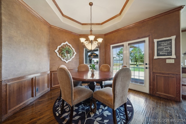 dining space with a raised ceiling, crown molding, dark hardwood / wood-style flooring, and a chandelier