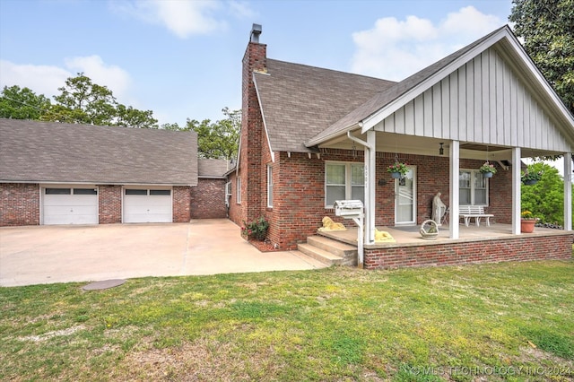 view of front of house with covered porch, a front yard, and a garage