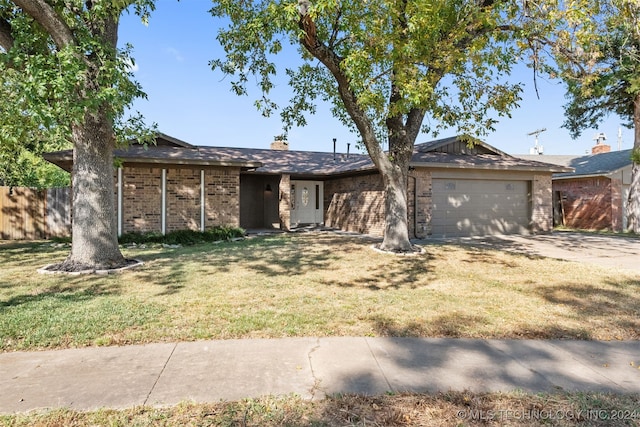 single story home featuring a garage and a front lawn