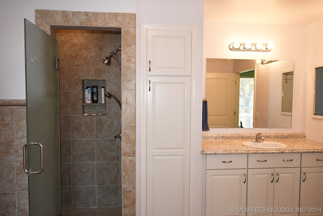 bathroom with vanity and a shower with door