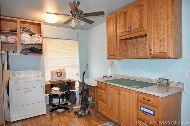 kitchen with washer / dryer, ceiling fan, light stone countertops, and light hardwood / wood-style flooring