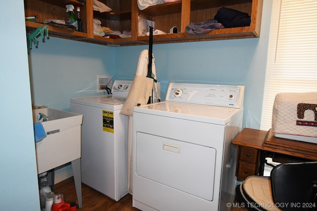 washroom with dark wood-type flooring, sink, and washing machine and clothes dryer