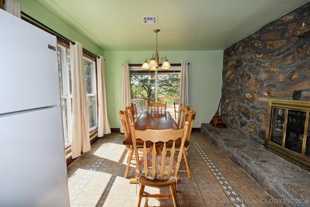 tiled dining space featuring a notable chandelier