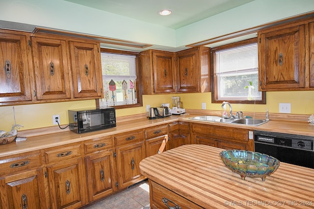 kitchen featuring light tile patterned flooring, sink, and black appliances