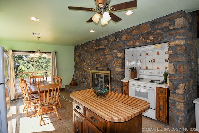 kitchen featuring stainless steel fridge, a stone fireplace, backsplash, white electric range, and tile patterned flooring