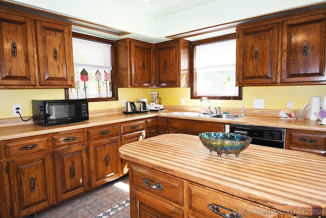 kitchen featuring dark tile patterned floors, black appliances, wooden counters, and sink