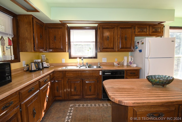 kitchen featuring sink, dark tile patterned floors, and black appliances