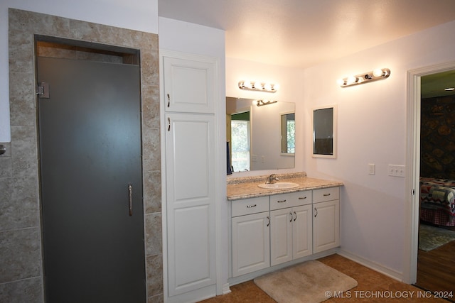 bathroom featuring walk in shower and vanity