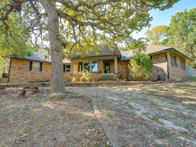 view of front of home featuring roof with shingles and brick siding