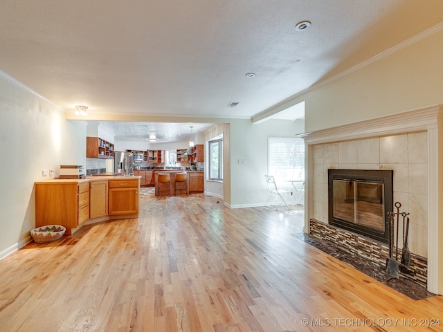 kitchen with stainless steel fridge with ice dispenser, light hardwood / wood-style floors, and a textured ceiling